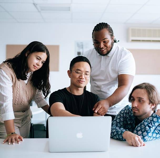 sae-music-business-course-what-youll-learn A group of students watching over a laptop.