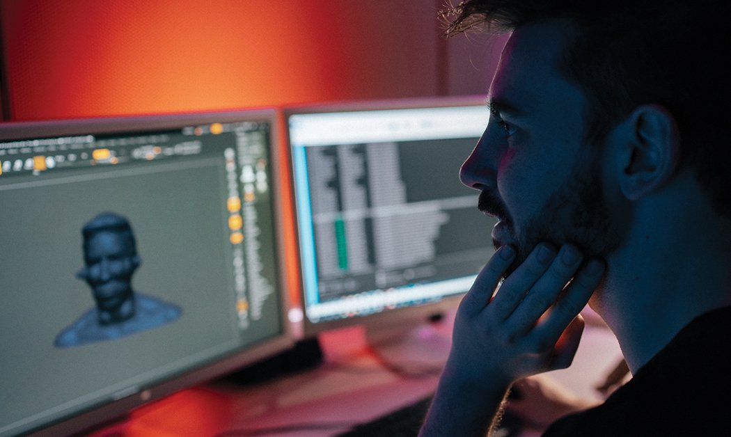 A close-up of a student working with game design software on a computer.