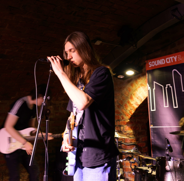 sound-city-festival a long-haired singer performing on stage